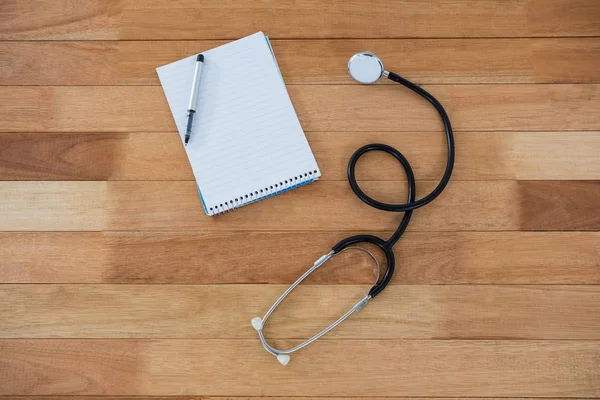 Stethoscope with pen on notebook — Stock Photo, Image