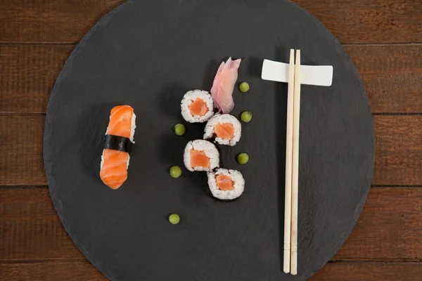 Nastavit různé sushi podávané s hůlkami na černý kámen břidlice — Stock fotografie