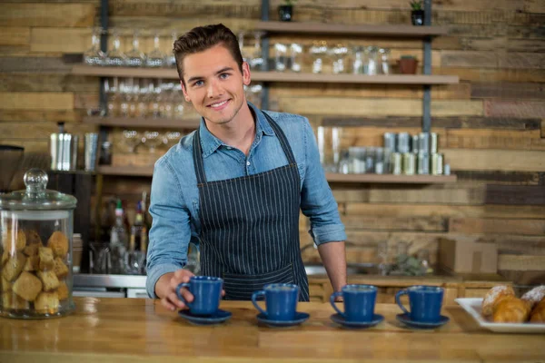 Serveur souriant préparer une tasse de café au comptoir — Photo