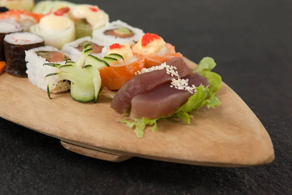 Assortiment de sushis servi dans une assiette de bateau en bois — Photo