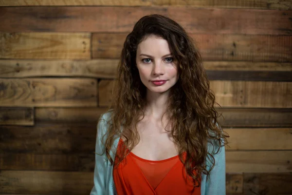 Portrait de femme debout contre un mur en bois — Photo