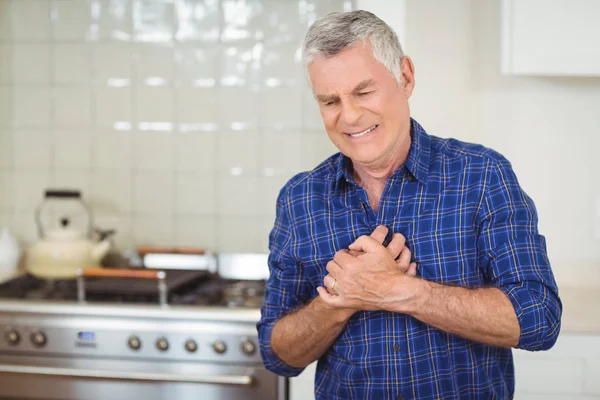 Old senior man suffering from heart attack in kitchen — Stock Photo, Image