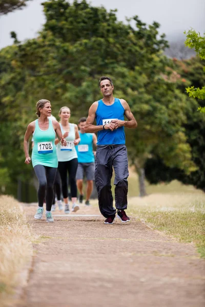 Athletes running race in park — Stock Photo, Image