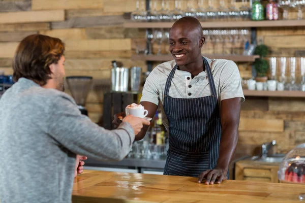 Camarero que sirve café al cliente masculino — Foto de Stock