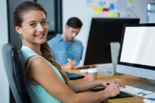 Diseñadora gráfica femenina usando tableta gráfica en el escritorio — Foto de Stock