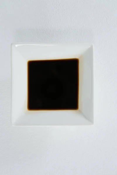 Molho de soja em uma tigela quadrada no fundo branco — Fotografia de Stock