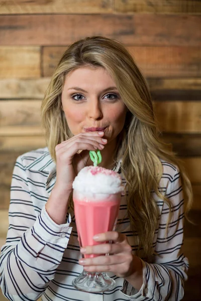 Retrato de una mujer bebiendo batido con paja — Foto de Stock