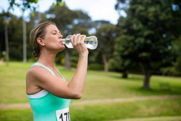 公園で水を飲む女性アスリート — ストック写真