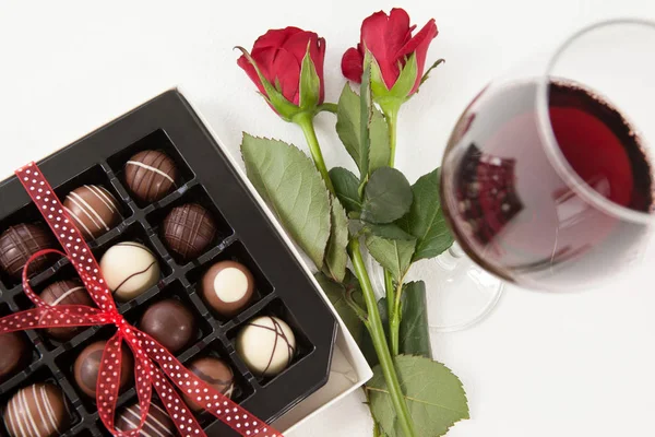 Ramo de rosas, botella de champán, copa de vino y caja de chocolate surtido — Foto de Stock