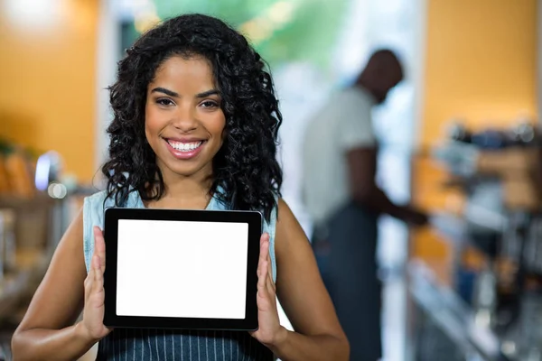 Портрет усміхненої офіціантки, що показує цифровий планшет — стокове фото
