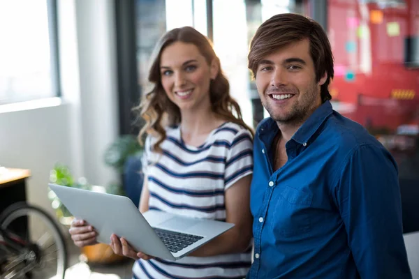 Cadres d'entreprise masculins et féminins tenant ordinateur portable — Photo