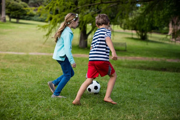 Menino e menina jogando futebol — Fotografia de Stock