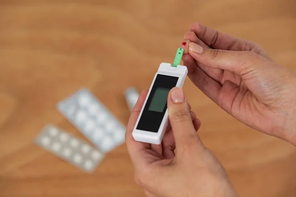 Close-up of woman hands testing blood sugar with glucometer — Stock Photo, Image