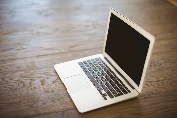 Laptop op houten vloer — Stockfoto