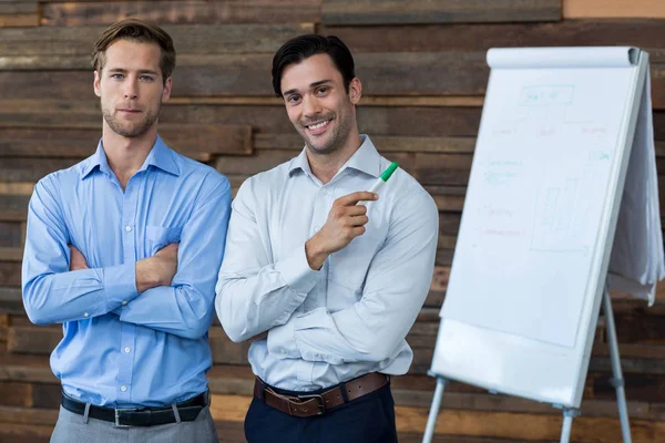 Twee mannelijke zakenmensen in een vergadering staan voor een flip-over — Stockfoto