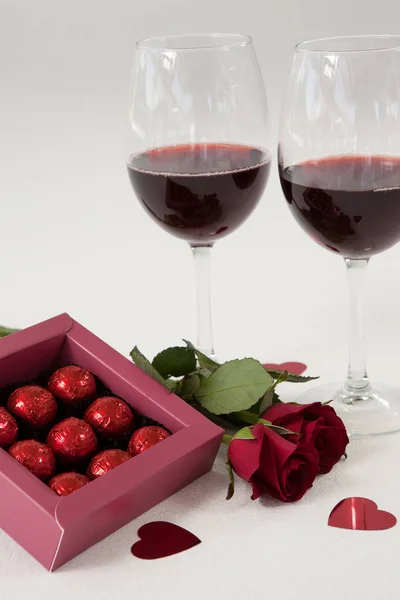 Bouquet de roses, verres à vin et boîte de chocolat assortie — Photo