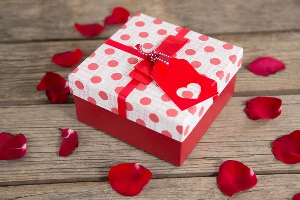Подарункова коробка в оточенні пелюсток троянд — стокове фото