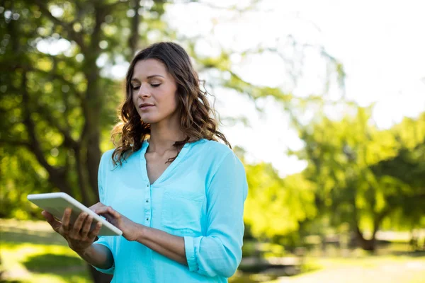 Жінка використовує цифровий планшет у парку — стокове фото