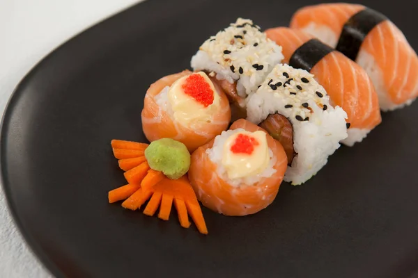 Maki, uramaki och nigiri sushi serveras i svart plåt mot vit bakgrund — Stockfoto