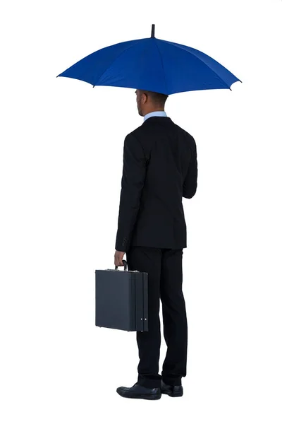 Zakenman holding blauwe paraplu en een werkmap — Stockfoto