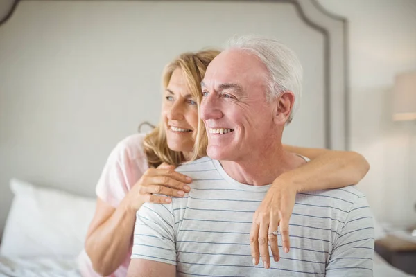 Lachende vrouw omhelst man op bed — Stockfoto