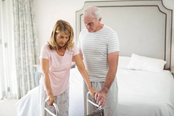 Senior mannen att hjälpa kvinnan att gå med rullator — Stockfoto