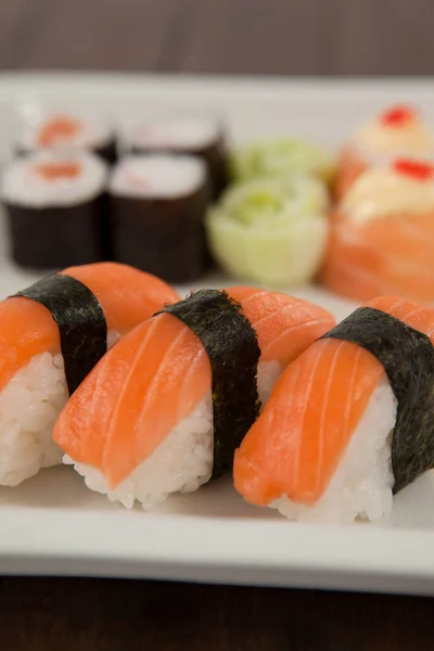 Trois sushis nigiri servis dans une assiette blanche — Photo