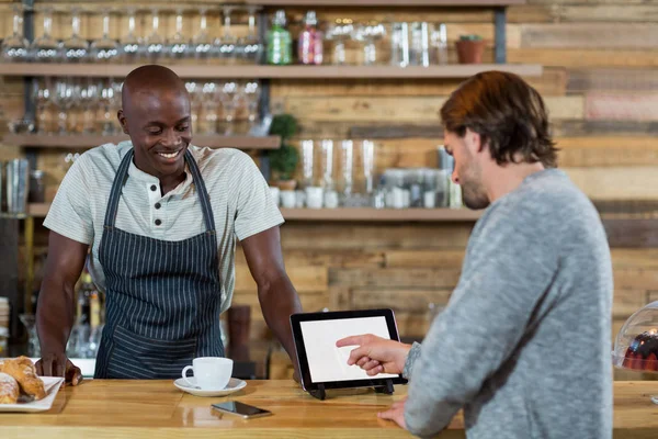 Hombre discutiendo sobre tableta digital con camarero — Foto de Stock