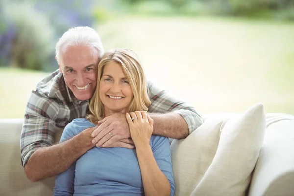 Portrét usměvavá starší muž objímá žena v obývacím pokoji — Stock fotografie
