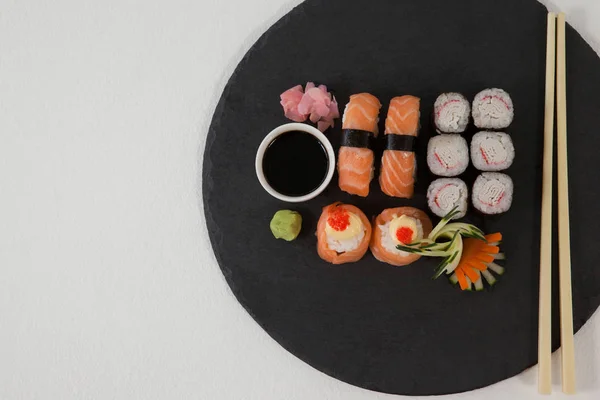 Nastavit různé sushi podávané na černý kámen břidlice se sojovou omáčkou a hůlky — Stock fotografie