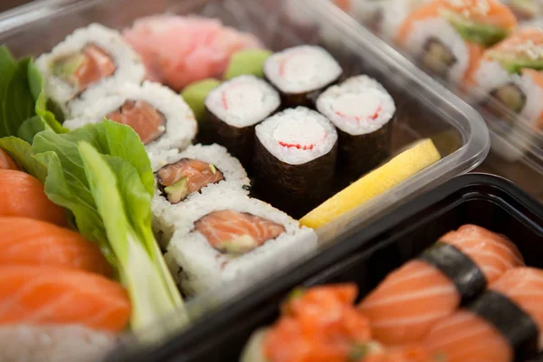 Conjunto de sushi sortido servido em caixas de plástico — Fotografia de Stock