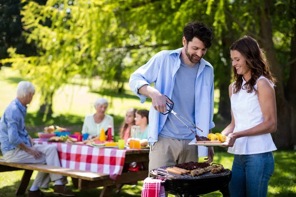 Couple preparing barbeque in park — Stock Photo, Image