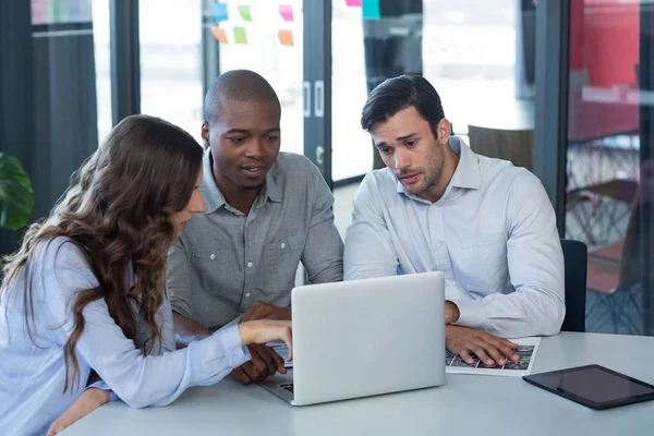 Team of graphic designers discussing over laptop — Stock Photo, Image
