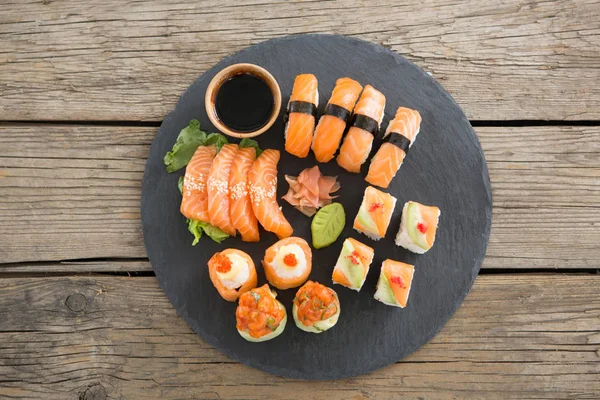 Conjunto de sushi variado servido em ardósia de pedra preta — Fotografia de Stock