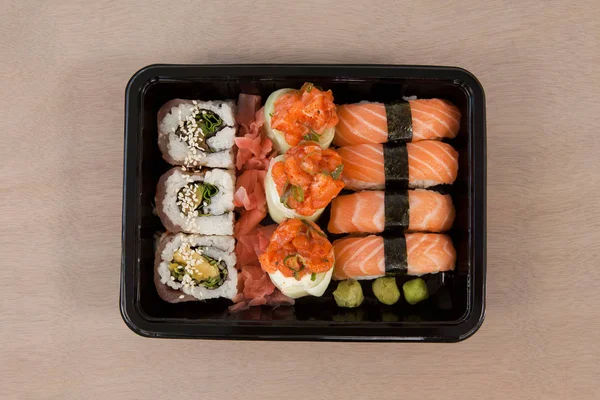 Uppsättning av blandade sushi höll i en svart låda — Stockfoto