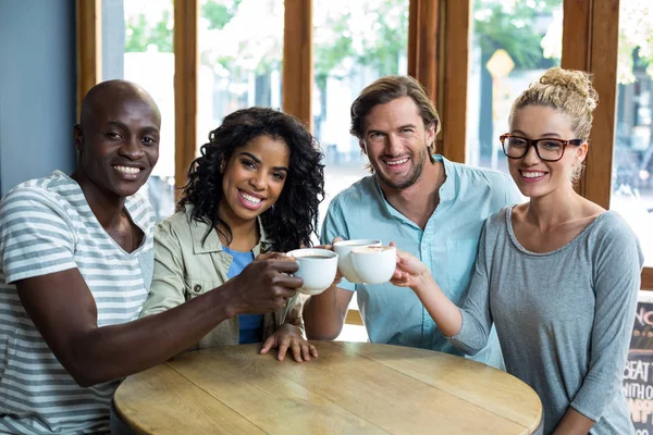 Grupo de amigos felices tostando taza de café en la cafetería —  Fotos de Stock