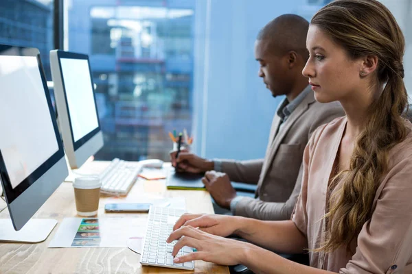 Grafikdesignerin arbeitet am Schreibtisch mit Kollegin — Stockfoto