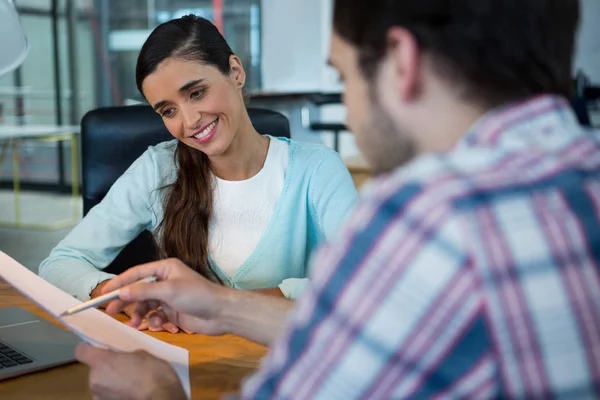 Leende företagsledare diskuterar över dokument — Stockfoto