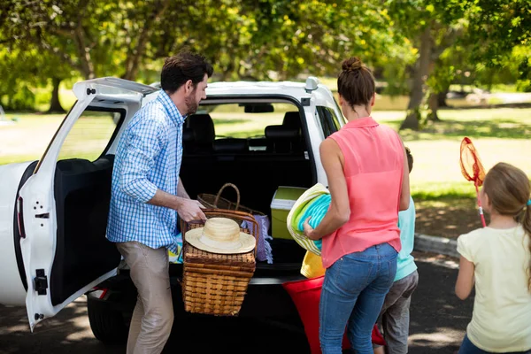 Famille placer des articles de pique-nique dans le coffre de voiture — Photo