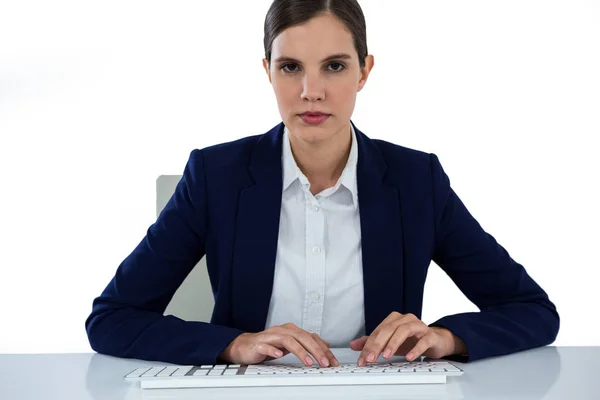 Porträt einer Geschäftsfrau, die am Schreibtisch auf der Tastatur tippt — Stockfoto