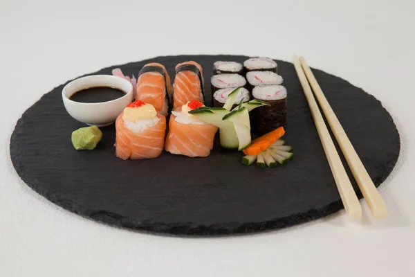 Uppsättning av blandade sushi serveras på svart sten skiffer med ätpinnar och sojasås — Stockfoto