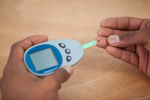 Close-up of man hands testing blood sugar with glucometer — Stock Photo, Image