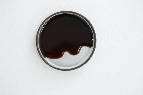 Chocolate syrup on plate against white background — Stock Photo, Image
