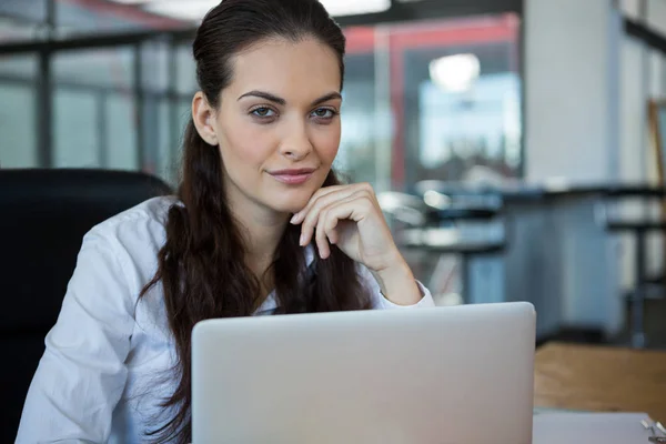 Female business executive sitting with laptop — Stock Photo, Image