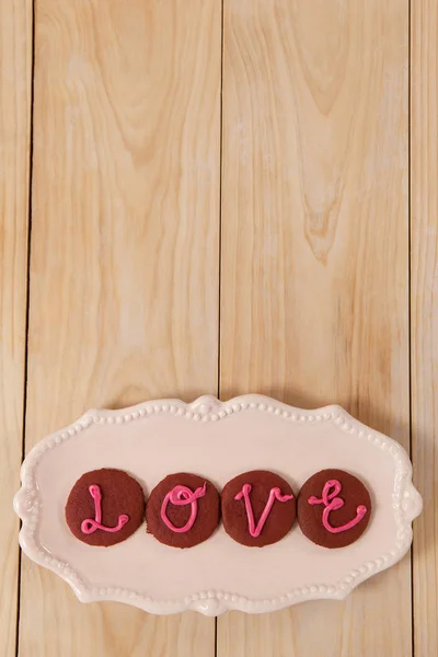 Biscoitos gelados com creme rosa exibindo amor — Fotografia de Stock