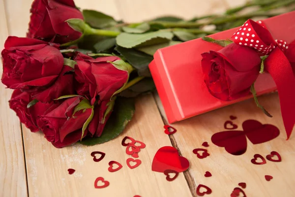 Троянди і подарункова коробка в оточенні прикраси серця — стокове фото
