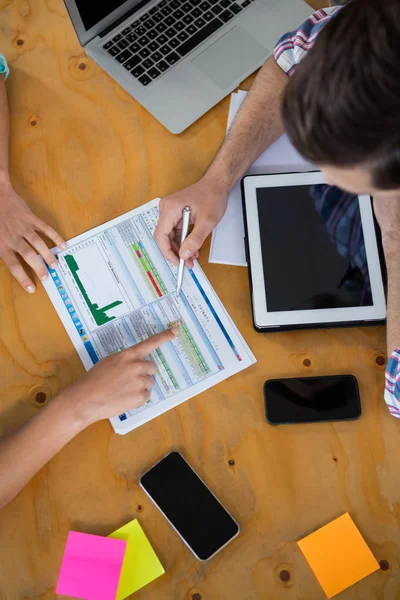 Leidinggevenden bespreken van grafieken en diagrammen op Bureau — Stockfoto