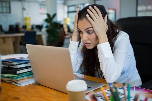 Upset female graphic designer looking at laptop — Stock Photo, Image