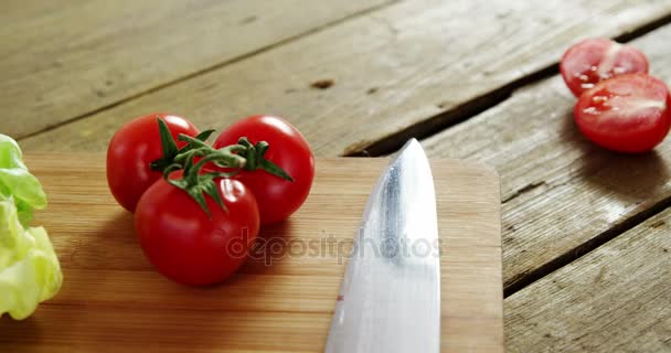 Hortalizas y cuchillo de cocina en tabla de cortar — Vídeos de Stock