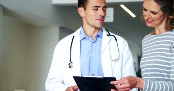 Mother and doctor discussing over clipboard — Stock Video